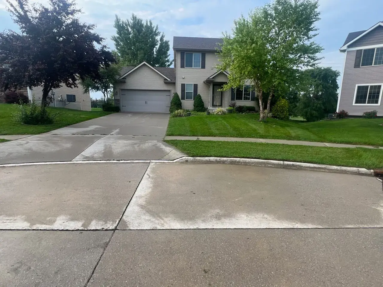 Healthy green front lawn at a home, kept up by Stretch, a lawn care company serving Urbandale