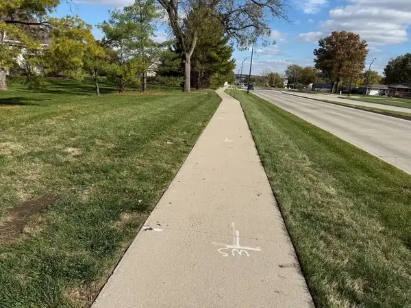 Hard surface edging along driveway and sidewalks following weekly lawn care service in the Royal Park neighborhood of Johnston, IA.