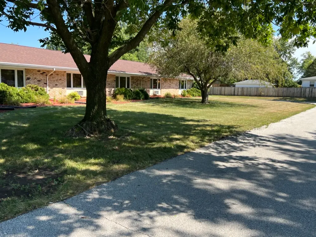 Mowed lawn and shade trees beside a driveway at a Polk City, IA property