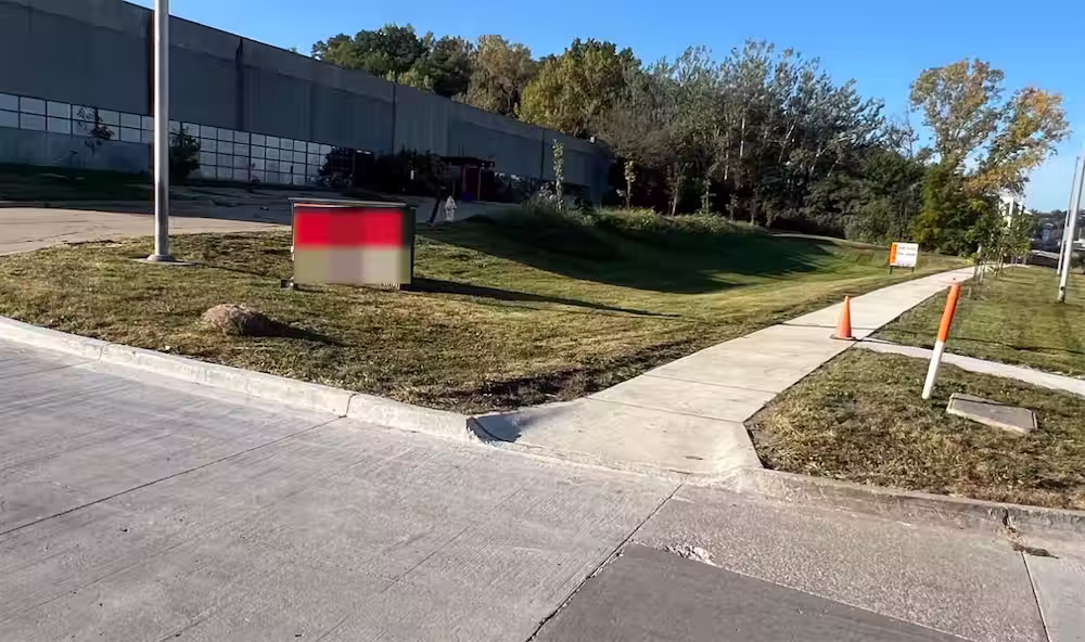 Freshly mowed grounds and sidewalk edges at a commercial property in Des Moines, IA, maintained by Stretch Property Maintenance