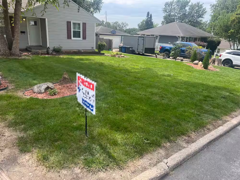 Freshly mowed, striped front lawn at a home in Des Moines, IA, by Stretch Property Maintenance