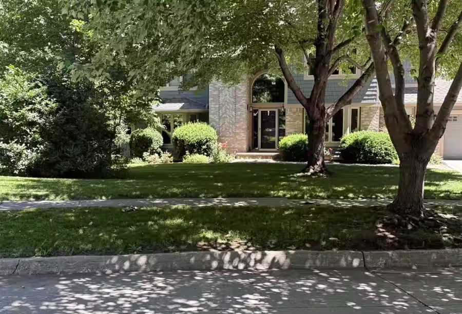 Freshly mowed and edged front lawn with shade trees, weekly lawn mowing in Johnston, IA by Stretch Property Maintenance